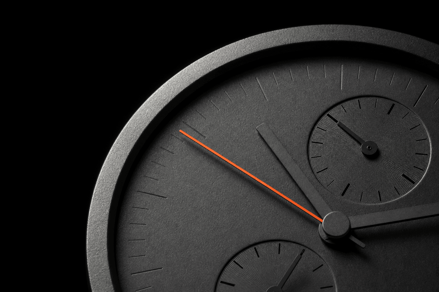 Macro photograph of a grey chronograph dial with a single orange hand